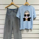 Light blue graphic tee with stylish woman print paired with wide-leg denim jeans, modern casual outfit