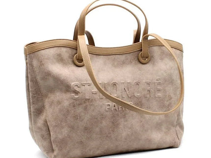 Beige suede tote bag with embossed logo, dual top handles, and shoulder strap for everyday luxury style.