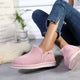 Pink suede ankle boots with white soles, styled with ripped jeans on cozy rug