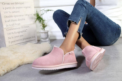 Pink suede ankle boots with white soles, styled with ripped jeans on cozy rug