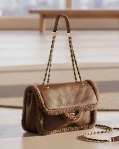 Luxury brown leather handbag with chain strap and shearling trim, elegant designer accessory