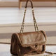 Luxury brown leather handbag with chain strap and shearling trim, elegant designer accessory