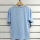 Light blue oversized t-shirt on wooden hanger, minimalist design for casual luxury style