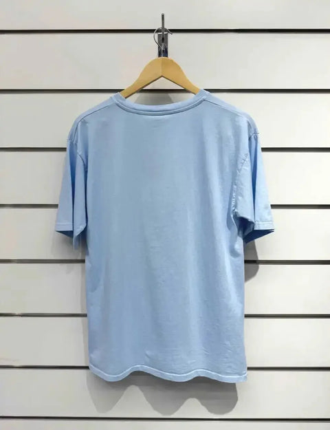 Light blue oversized t-shirt on wooden hanger, minimalist design for casual luxury style
